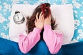 Young girl annoyed by the alarm clock Royalty Free Stock Photo