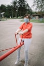 Young girl with antivirus mask enjoying playground facilities