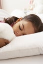 Young Girl Asleep In Bed With Cuddly Toy