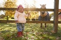 Young Girl On Autumn Walk Looking At Pony In Field Royalty Free Stock Photo