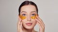 Young girl applying golden collagen patches under the eyes. Mask for removing wrinkles and dark circles Royalty Free Stock Photo