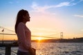 Young girl on background of Bosphorus bridge and sunset Royalty Free Stock Photo