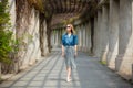 Girl walking on alley with arches and columns Royalty Free Stock Photo