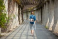 Girl walking on alley with arches and columns Royalty Free Stock Photo