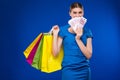 Young girl with bags and bunch of money in the hands of Royalty Free Stock Photo