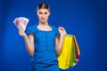 Young girl with bags and bunch of money in the hands of Royalty Free Stock Photo