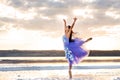 A young girl in a ballet dress stands in the water with clouds reflected. Royalty Free Stock Photo