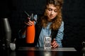 Young girl at bar holds orange siphon in her hand Royalty Free Stock Photo