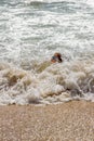 Young Girl Barely Keeping Her Head Above Water In the Foamy Ocean Surf On The Beach Royalty Free Stock Photo