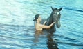 Girl bathe horse in a river