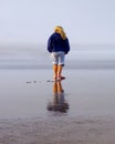 Young Girl on Beach with Reflection in Wet Sand