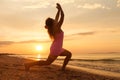 Young girl the beach at sunrise doing yoga exercise Royalty Free Stock Photo