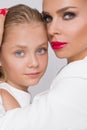 The young girl with the beautiful daughter of an amazing blue eyes and red lips and nails mom blond curly hair long dense sit hudd Royalty Free Stock Photo