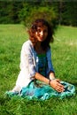 Young girl in beautiful ethno dress praying on meadow.