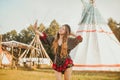 Young girl beautiful tourist take photo selfie, video communication and smiling, on the background teepee / tipi- native indian