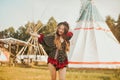 Young girl beautiful tourist take photo selfie, video communication and smiling, on the background teepee / tipi- native indian