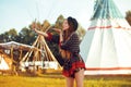 Young girl beautiful tourist take photo selfie, video communication and smiling, kiss on the background teepee / tipi- native indi