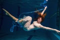 Young girl in beautiful white dress posing underwater Royalty Free Stock Photo