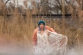 A young girl in a beautiful white dress and a stylish hat poses in a wheat field Royalty Free Stock Photo