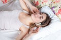 The young girl in bed listening to music Royalty Free Stock Photo