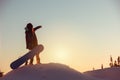 Young girl snowboarder stands at sunset mountain top Royalty Free Stock Photo