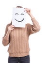 Girl covers her face with a leaf with a smiling smiley on a white background