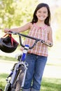 Young girl with bicycle outdoors smiling