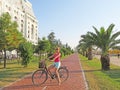 A young girl on a bicycle is riding along the waterfront. The ci Royalty Free Stock Photo