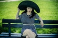 Young girl with big black pigeon sitting on a wooden bench in a Royalty Free Stock Photo