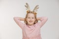 Young girl with a big smile holding her hands behind her head on the deer antler head