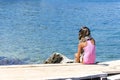 Young girl in bikini and headphones, listening to music on a pier Royalty Free Stock Photo