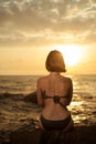 Young girl in bikini sitting on a rock on a seaside. Royalty Free Stock Photo