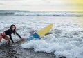 Young girl in bikini - surfer with surf board dive underwater with fun under big ocean wave. Family lifestyle, people