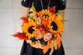 Young girl in black dress with a bright bouquet of berries in hands.