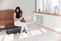 A young girl a black jacket and white trousers  is resting on a table Royalty Free Stock Photo