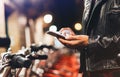 Young girl in black leather jacket using smartphone on background illumination glow bokeh light in night atmospheric city, hipster Royalty Free Stock Photo