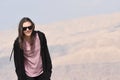 A young girl in a black sweatshirt and sunglasses on the background of rocks on the mountainside near the fortress of Al Karak in Royalty Free Stock Photo