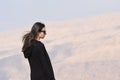 A young girl in a black sweatshirt and sunglasses on the background of rocks on the mountainside near the fortress of Al Karak in Royalty Free Stock Photo