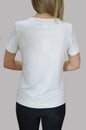 A young girl in a blank white t-shirt and black shorts, on a light background. Back view. Layout, mocap, free space for text, logo Royalty Free Stock Photo