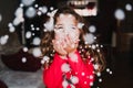 young girl blowing artificial snow flakes at home. Christmas concept Royalty Free Stock Photo