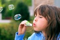 Young girl blowing bubbles