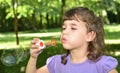 Young girl blowing soap bubbles