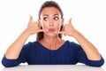 Young girl in blue blouse gesturing a call Royalty Free Stock Photo