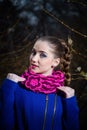 Young girl in blue coat and pink striped knitted snood scarf with flower brooch. Female autumn and winter clothing and accessories Royalty Free Stock Photo