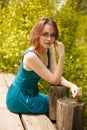 Young girl in blue dress sitting on wooden pier Royalty Free Stock Photo