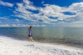 Young girl in in blue dress walking at lake beach Royalty Free Stock Photo