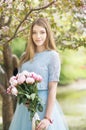 Young girl with a bouquet of peonies in the park, garden. Summer, spring Royalty Free Stock Photo