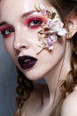 Young girl with bright pink creative make-up. Beautiful model with lips of the color of Marsala and application of flowers. Suspen