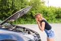 Young girl with broken down car and hood open call for help Royalty Free Stock Photo