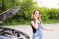 Young girl with broken down car and hood open call for help Royalty Free Stock Photo